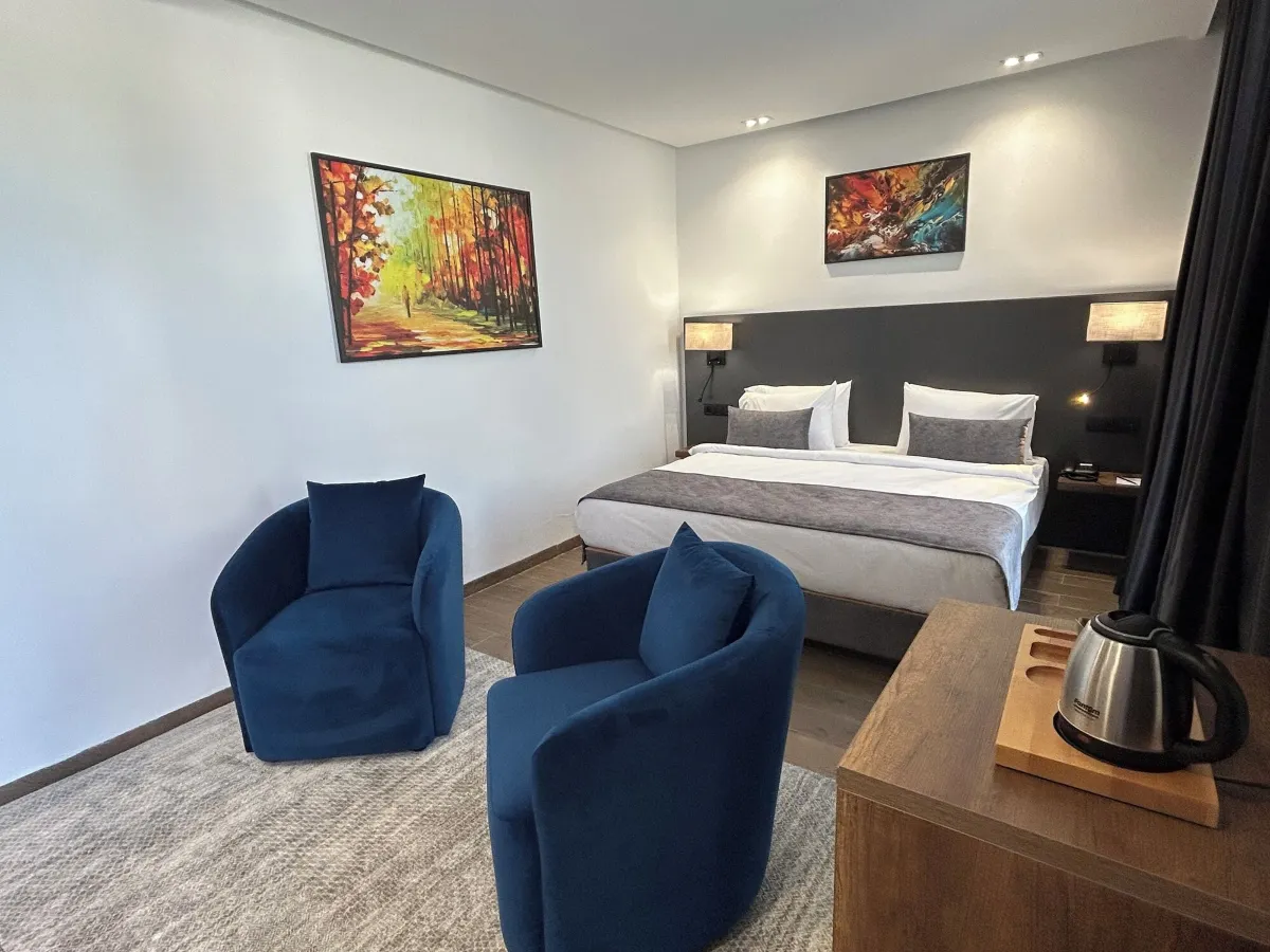 Executive Suite with a double bed and a pair of lounge armchairs