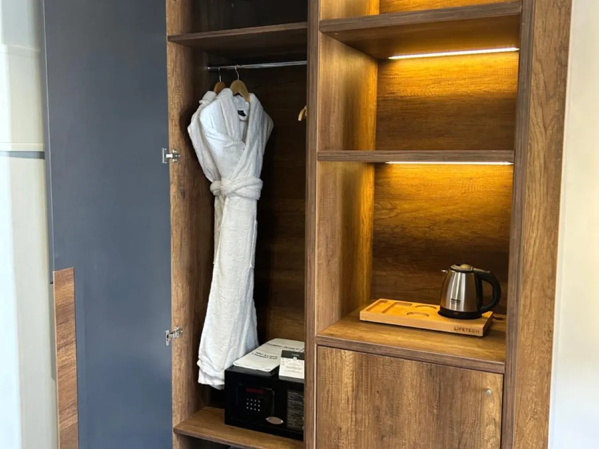 Open wardrobe with bathrobe, in-room safe and electric kettle